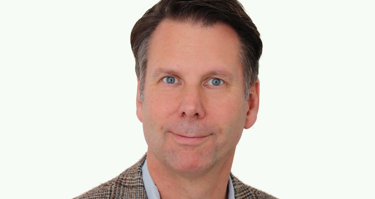Nils Wöbke A man with short brown hair wears a light blue shirt and a checked jacket