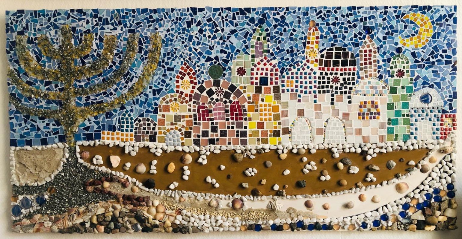 Mosaic artwork of buildings behind a brown courtyard.